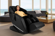 A woman enjoys a full-body massage in the Kyota Genki M380 Massage Chair, featuring advanced massage techniques and Bluetooth speakers.