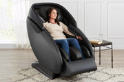 A woman sitting in a Kyota Kaizen M680 Massage Chair, experiencing a full-body massage with advanced kneading and compression features.