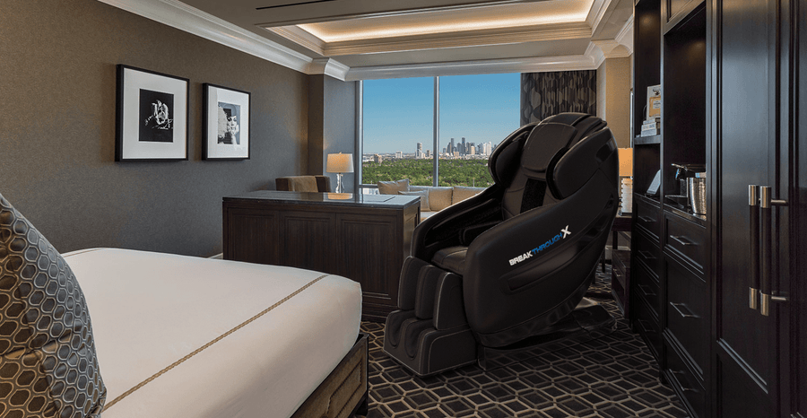 A black Medical Breakthrough 10 massage chair in a modern room with a city view.