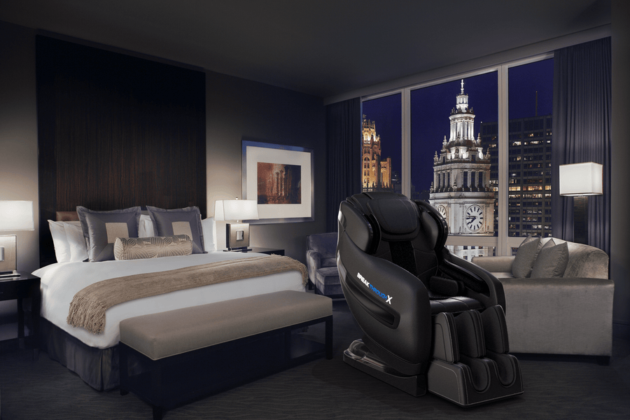 Medical Breakthrough 10 massage chair in a spacious room with a large bed and framed picture, designed to improve posture and reduce pain.