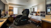 Medical Breakthrough 6 Plus massage chair in a hotel room, featuring advanced posture correction, pain relief, and sleep aid functionalities.