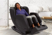 Woman sleeping in a Sharper Image Revival Massage Chair, shown in zero gravity recline, highlighting its full-body massage features.