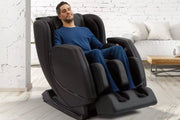 A man sitting in the Sharper Image Revival Massage Chair, showcasing its zero gravity recline and full-body massage features.